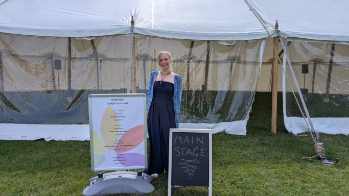 Clare standing outside the main stage at the Kent Wellness Festival